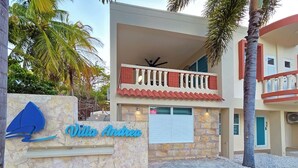 A hotel entrance with a stone facade, a sign reading 'Villa Andrea,' and a balcony with red railings. - Palmera Azul | Cozy Private Apartment in Cabo Rojo (Cabo Rojo)