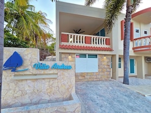 A hotel entrance with a stone facade, a sign reading 'Villa Andrea,' and a balcony with red railings. - Palmera Azul | Cozy Private Apartment in Cabo Rojo (Cabo Rojo)