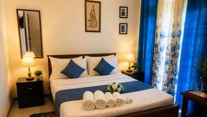 Ein Hotelzimmer mit einem Bett, zwei Nachttischen, einem Spiegel und einem Fenster mit Vorhängen.