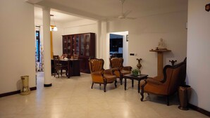 Ein geräumiges Wohnzimmer mit Essbereich, Deckenventilator und einer Statue auf einem Regal.