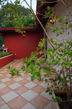 A red brick building with a tiled patio and a tree in the foreground. - Eco Serenity Kandy (Kandy)