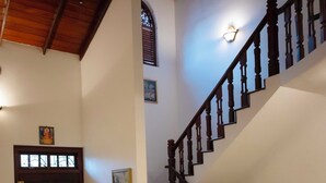 Eine Treppe mit Holzbalkonen und Handlauf, die zu einer oberen Etage führt.