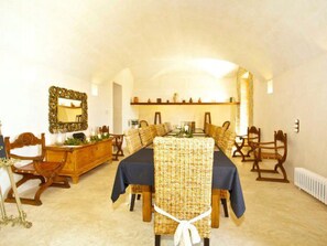A dining room with a long table, chairs, a buffet, and a mirror on the wall. - Luxuriöses Landhaus für 16 Personen mit Pool und by Interhome (Sant Llorenç des Cardassar)
