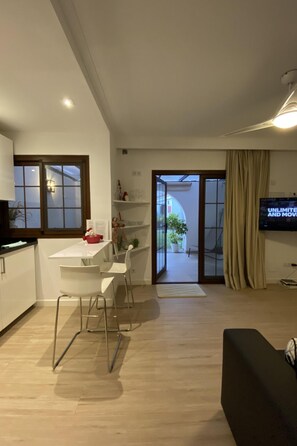 A modern living space with a dining area, a television, and a sliding glass door leading to an outdoor area. - für 4 Personen ca. 40 m² in Maspalomas, Gra by Interhome (Maspalomas)