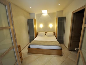 A bedroom with a bed, two wall-mounted lights, a door, and a window. - Appartement Nikae by Interhome (Cannes)