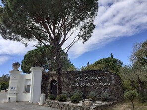Eine steine Mauer mit einem Schild, auf dem 'Les Restanque du Golfe de St Tropez' steht.