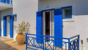 Ein Gebäude mit blauen Fensterläden, einem Blumentopf und einer gefliesten Eingangshalle.