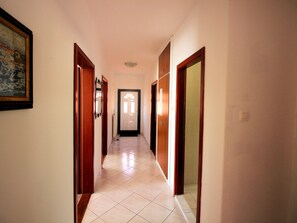 A corridor with wooden doors and a tiled floor, leading to a room with a door and a window. - Wohnung in Novi Vinodolski mit Grill, Garten und by Interhome (Novi Vinodolski)