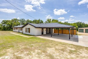 A single-story building with a covered patio area, a garage, and a well-maintained lawn.