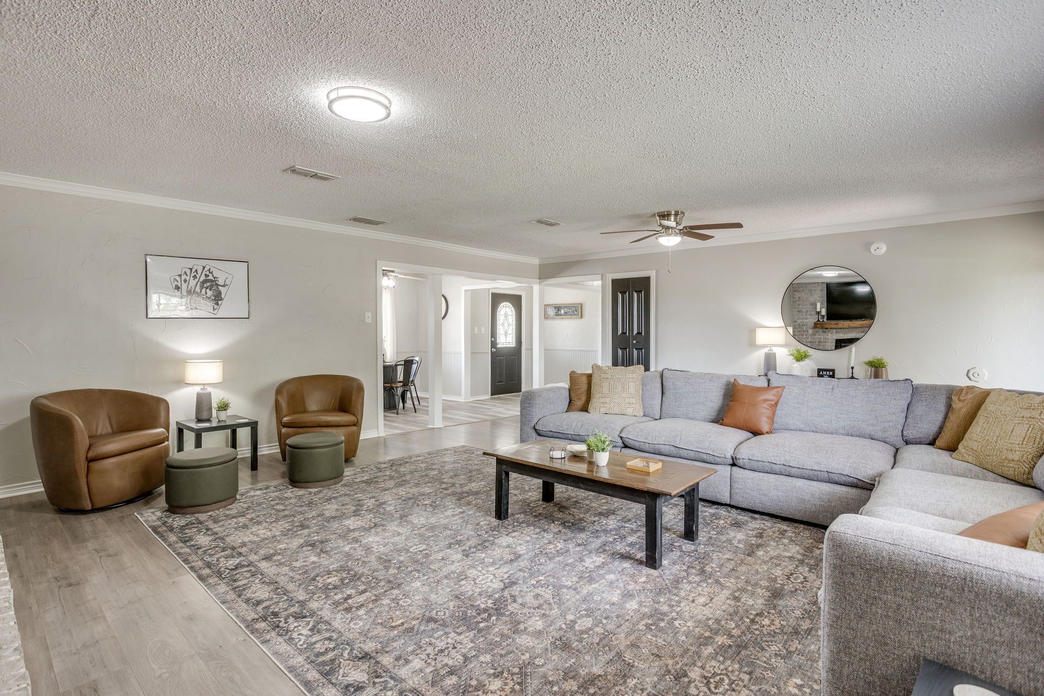 Un salon avec un canapé, des fauteuils, une table basse et un tapis.