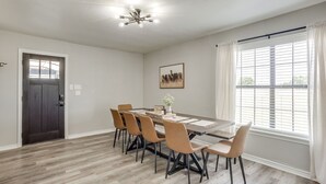 Een eethoek met een tafel, stoelen en een hanglamp.