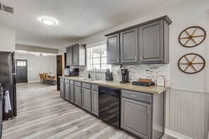 A modern kitchen with grey cabinets, a dishwasher, and a microwave.