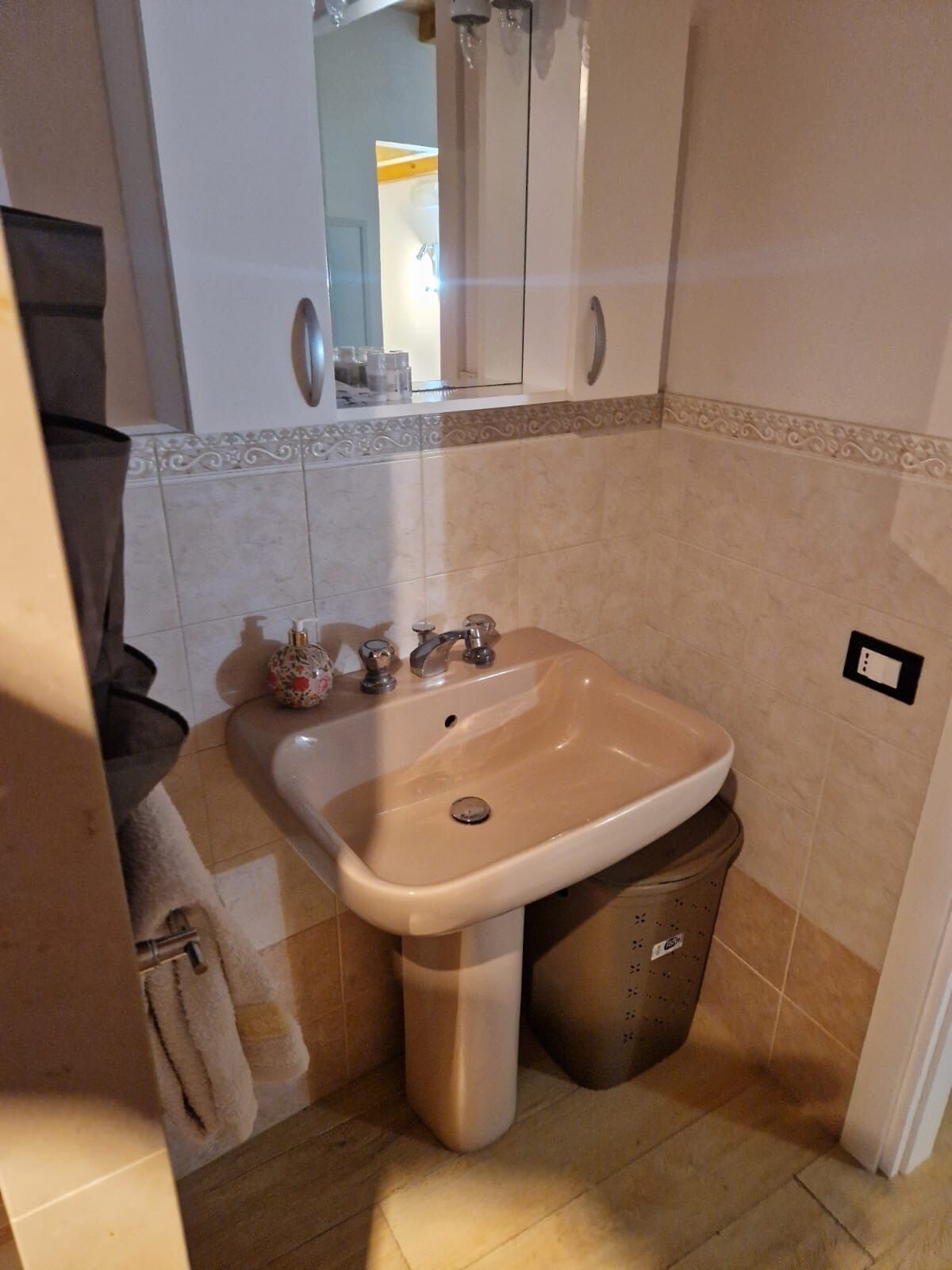Ein Badezimmer mit Waschbecken, Spiegel und Schrank.