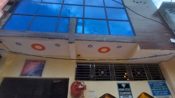 Un bâtiment doté d’une grande façade en verre, d’une lance d’incendie et de nombreux panneaux indiquant le type des pièces et les règles à respecter.