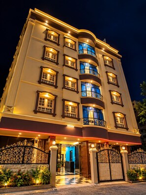 Ein mehrstöckiges Hotel mit einem prachtvollen Eingang, mehreren Balkonen und einer gut beleuchteten Fassade.