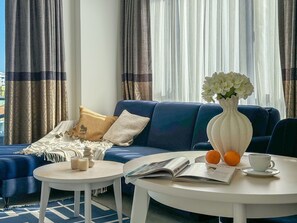 A modern living room with a blue sofa, a white coffee table, and a vase with flowers. - Qoople Eхсellence C-37 neue Wohnung am Meer by Interhome (Alanya)
