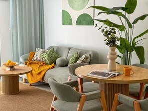 A living room with a grey sofa, a round wooden coffee table, and a large green plant. - Qoople Legend 37 А-12 100 Meter vom Strand entfernt by Interhome (Alanya)