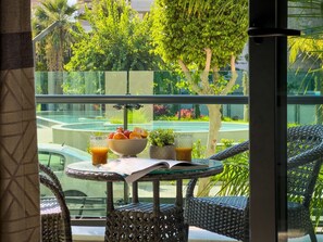 A balcony with a glass table, wicker chairs, a bowl of fruit, and a glass of orange juice. - Qoople Legend 36 A-04 100 Meter vom Strand entfernt by Interhome (Alanya)