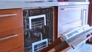 A kitchen with wooden cabinets, a dishwasher, and a tiled floor. - Spacious 2-bedroom, 2-bathroom apartment near the Colosseum in Rome (Roma)