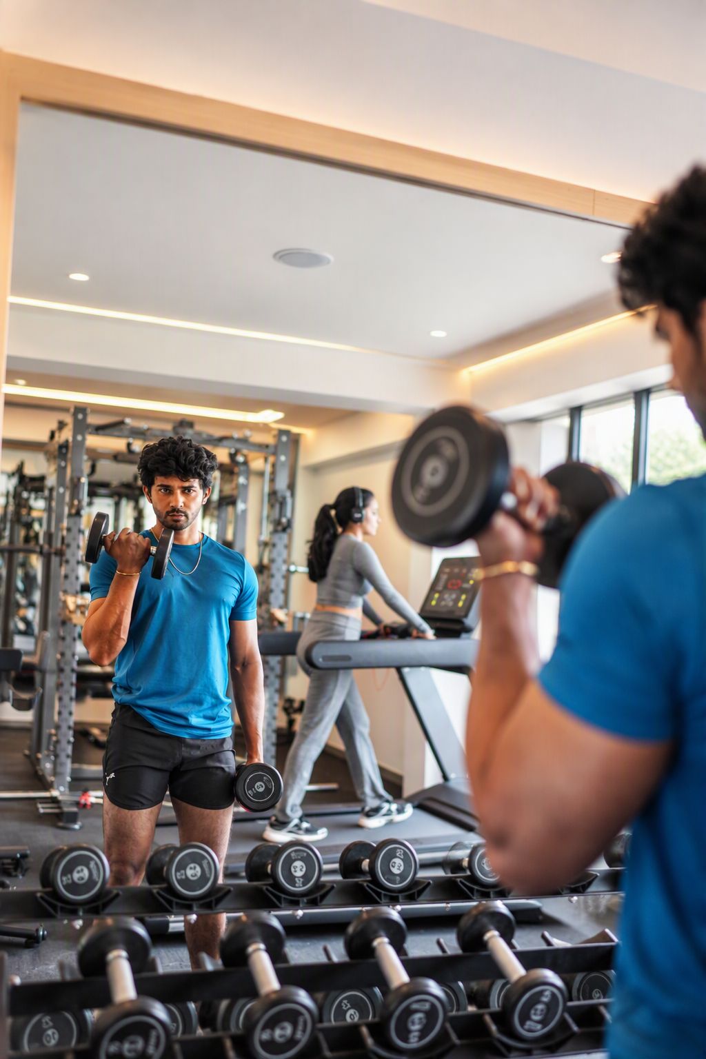 Un gimnasio con equipo de ejercicio, cintas de correr y estaciones de levantamiento de pesas.