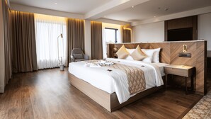 A modern hotel room with a large bed, a desk, and a chair. - Travancore Palace, Cochin (Aluva)