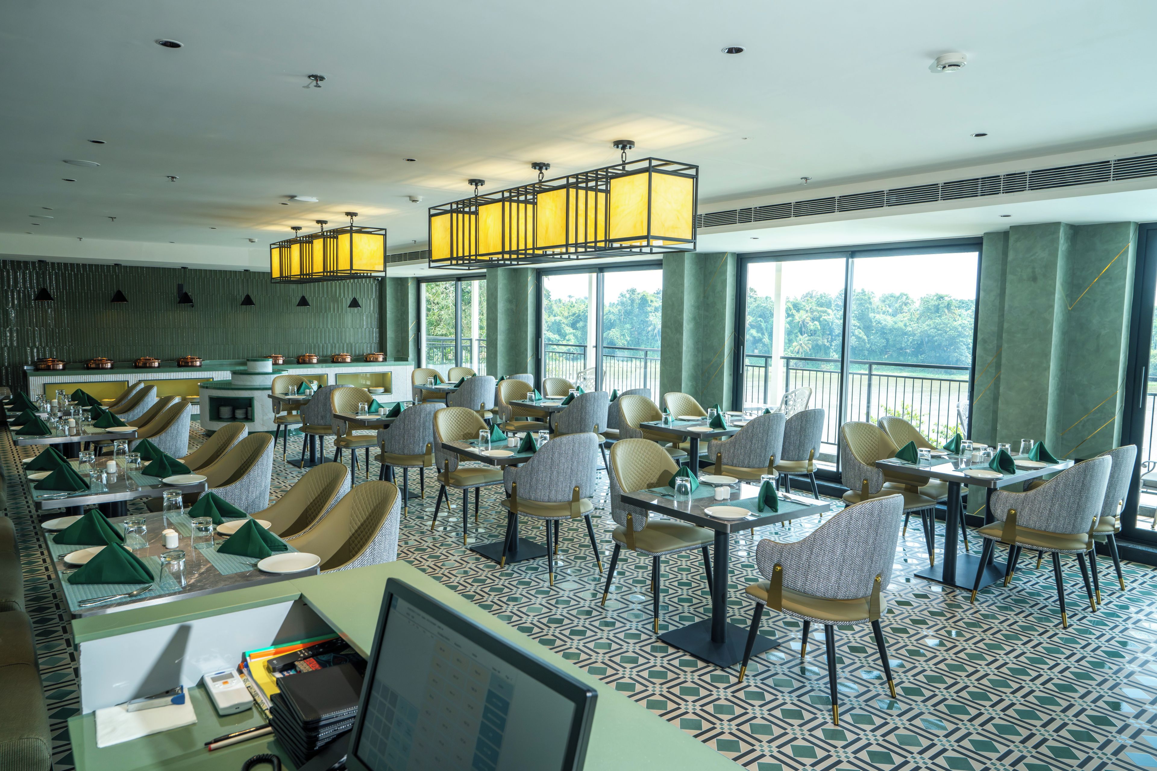A restaurant with a high ceiling, large windows, and a variety of seating arrangements including tables and chairs.