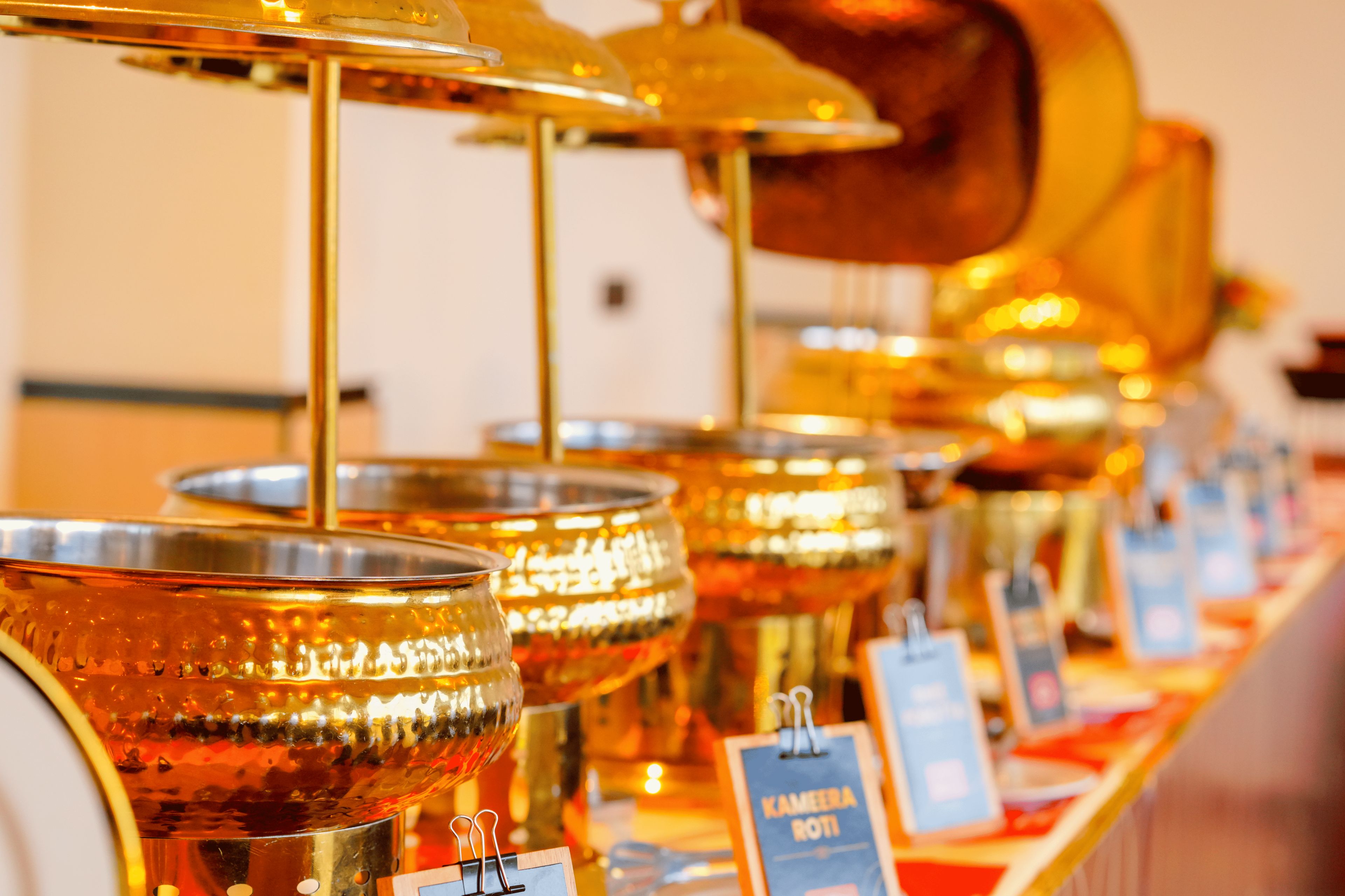 A row of metallic containers with labels, likely for food or beverages.