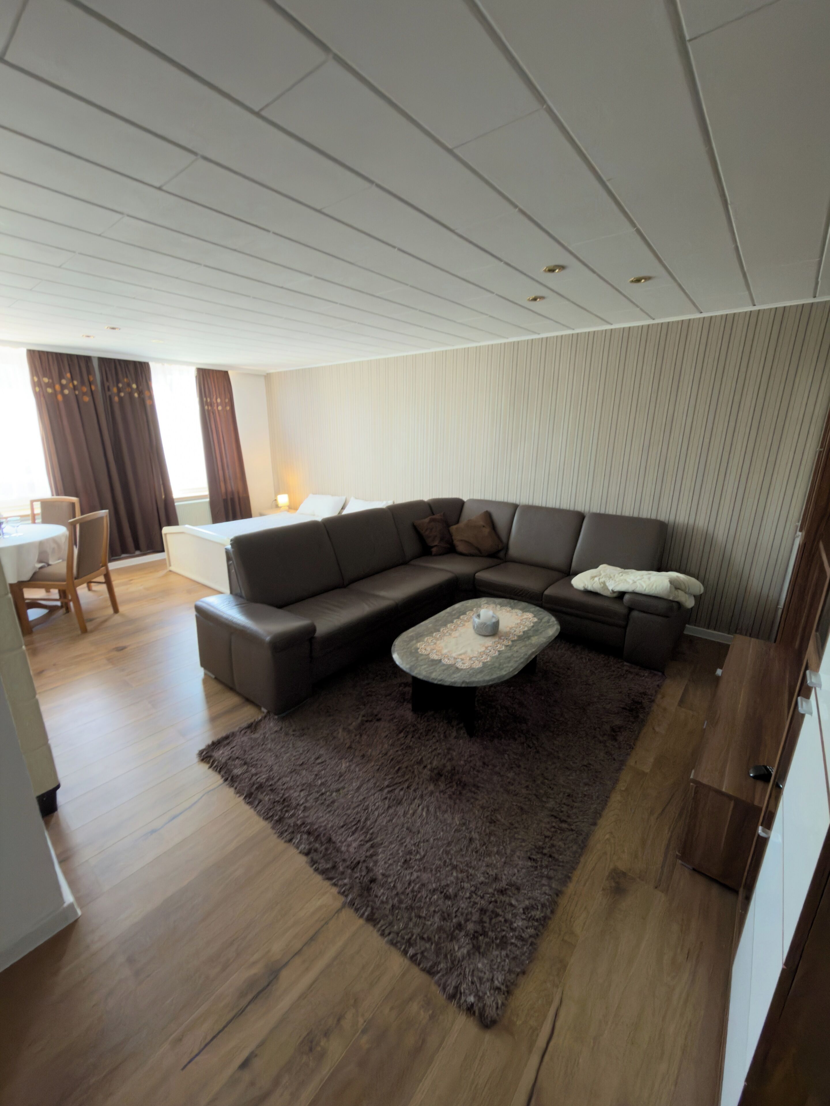 Een moderne woonkamer met een hoekbank, een salontafel en een vloerkleed.