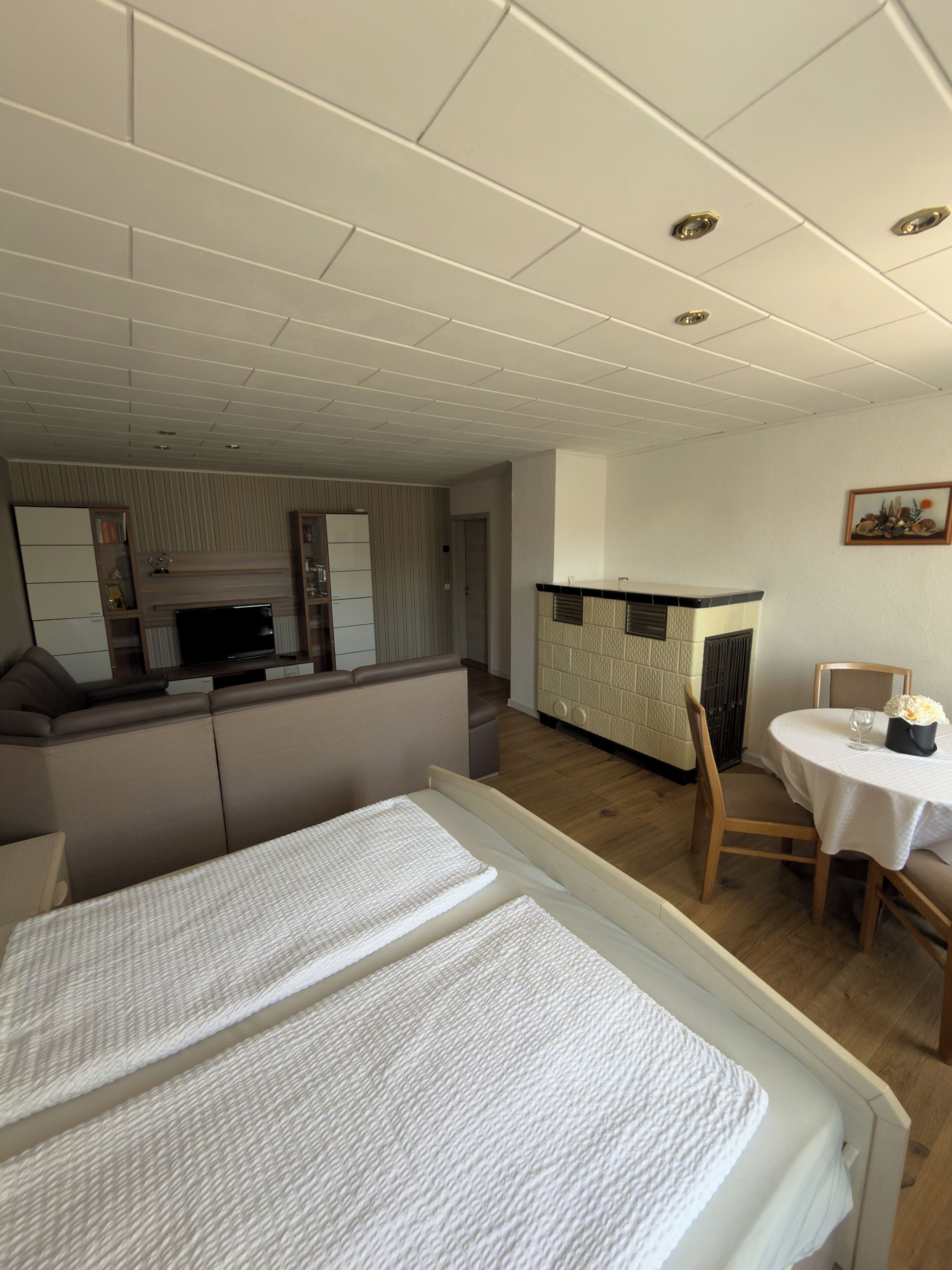 Een knus hotelkamer met een bed, een kleine kitchenette, een eettafel en een stoel.