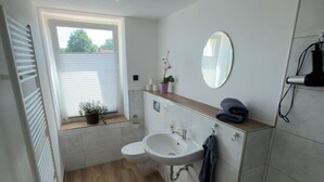 Une salle de bain avec des toilettes, un lavabo et un miroir.