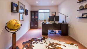 Ein Home-Office mit Schreibtisch, Computer und Globus.