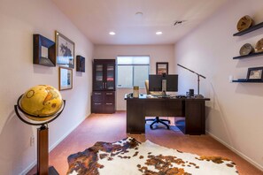 Ein Home-Office mit Schreibtisch, Computer und Globus.