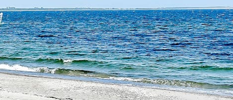 Une plage avec des vagues et un ciel dégagé.