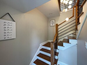 A staircase with wooden steps and a handrail, a wall-mounted sign with the phrase 'Be Kind,' and a framed sign that says 'today I choose joy.' - Spacious home for Large Group in Gainesviile (Gainesville)