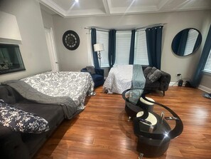 A bedroom with a bed, a sofa, a curved coffee table, and a mirror. - Spacious home for Large Group in Gainesviile (Gainesville)