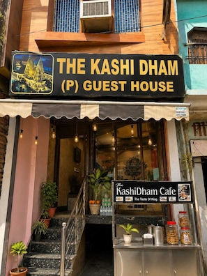 A guest house named 'The Kashi Dham (P) Guest House' with a signboard featuring a temple illustration. - Kashi Dham P Guest House (Varanasi)