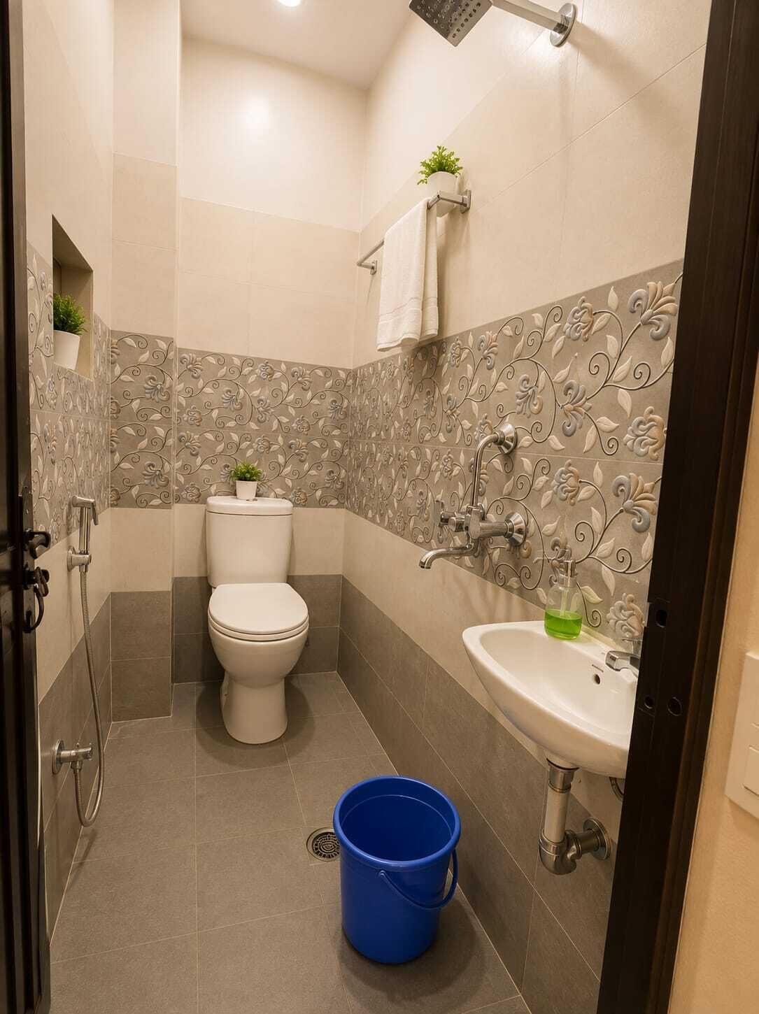 Baño con inodoro, lavamanos, ducha y azulejos decorativos.