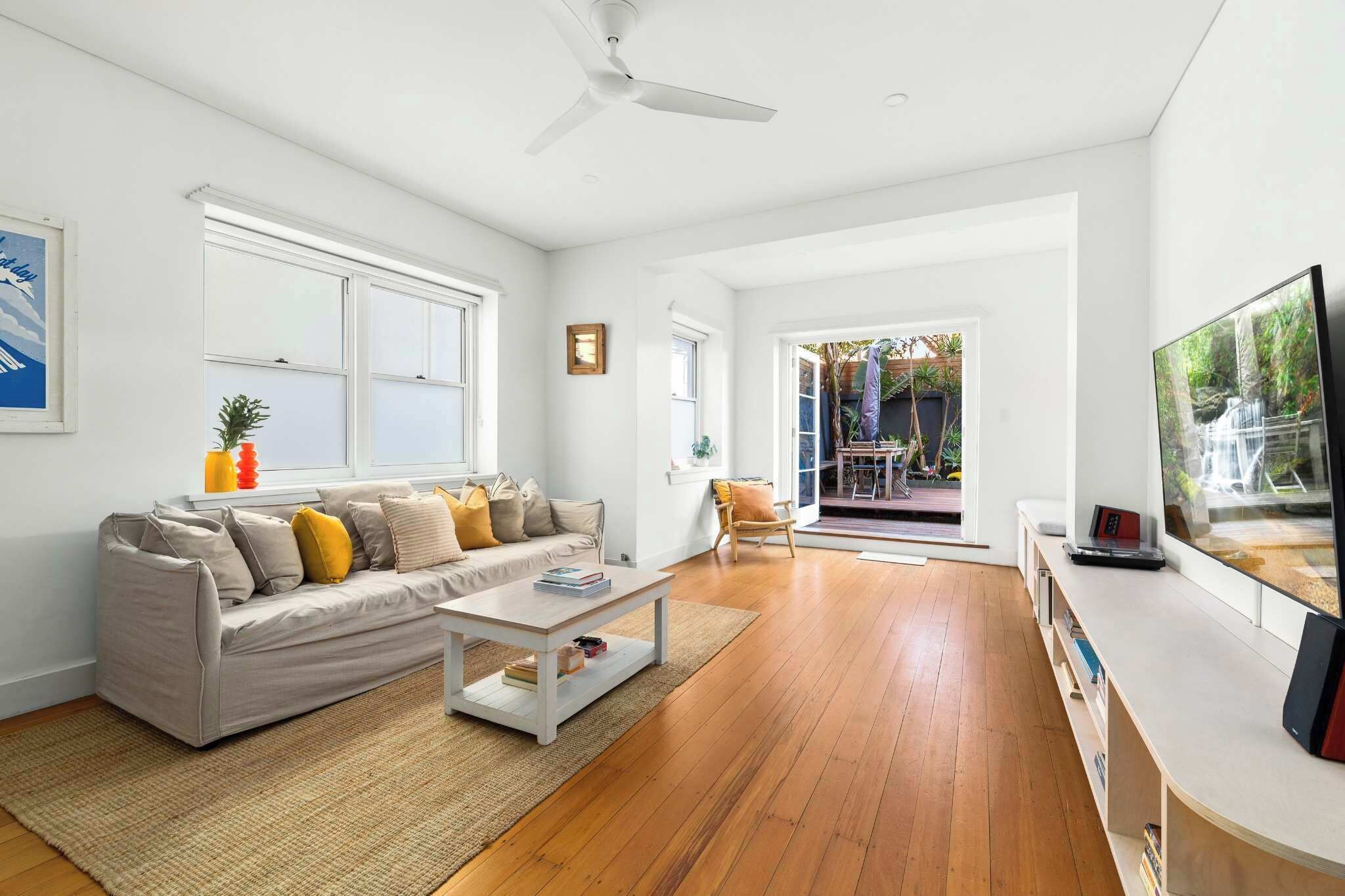 A modern living room with a sofa, coffee table, and a television.