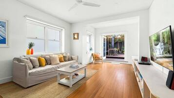A modern living room with a sofa, coffee table, and a television.