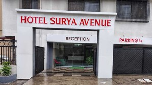 Der Eingang zum Hotel Surya Avenue mit einer Rezeption und einem Parkschild.