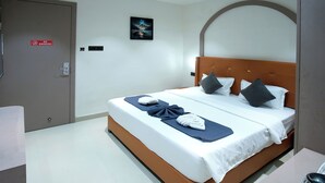 Ein Hotelzimmer mit einem Bett, einer Tür, einem Wandbild und einem Rauchverbot-Schild.