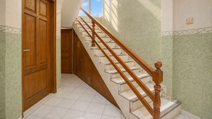 A staircase with wooden balusters leading to a landing. - Hotel O near City of Tomorrow Mall (Surabaya)