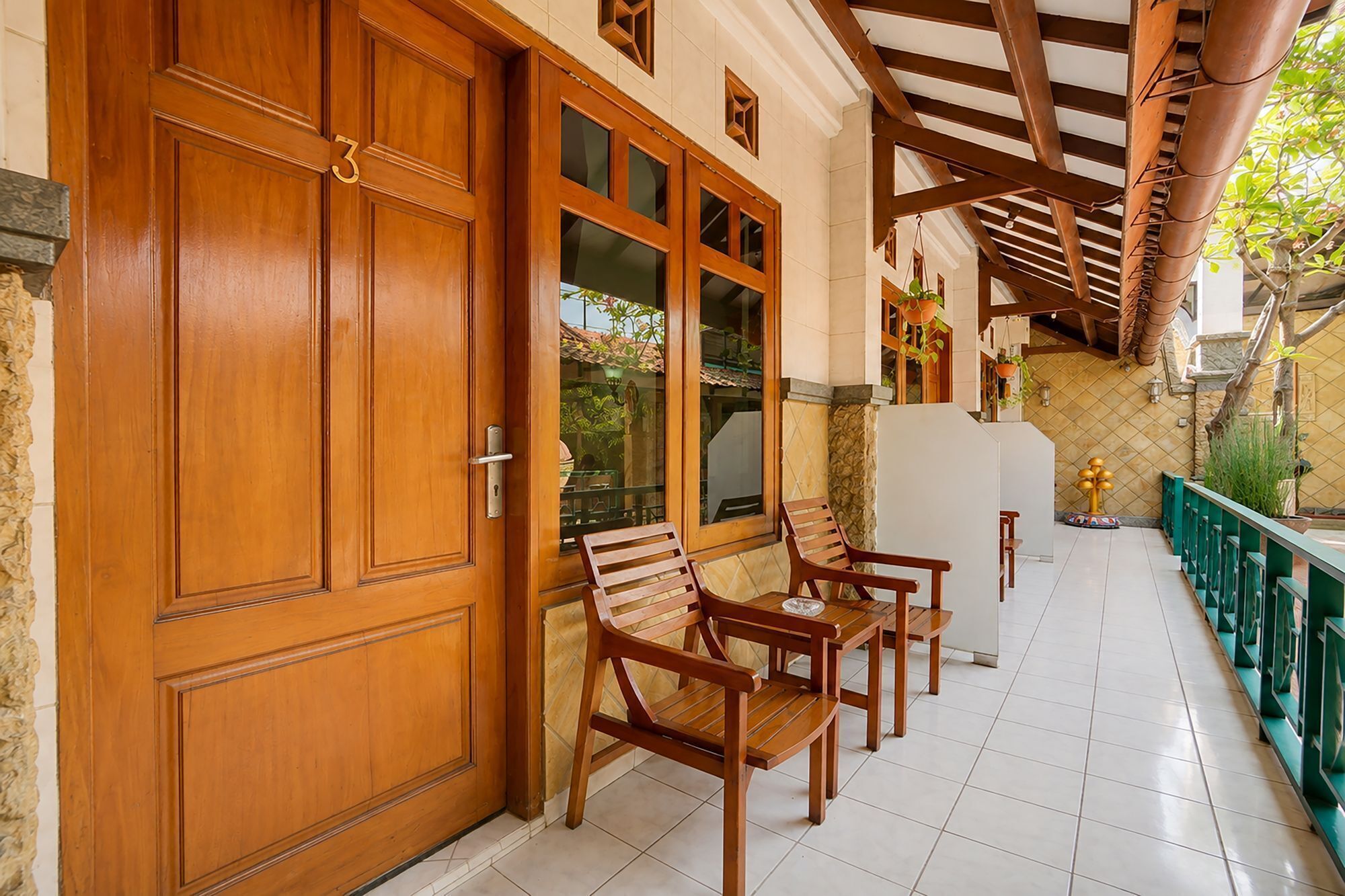 A wooden door with a number, a glass door, and a bench with a table.