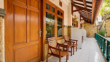 A wooden door with a number, a glass door, and a bench with a table.