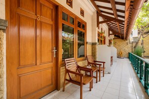 A wooden door with a number, a glass door, and a bench with a table. - Hotel O near City of Tomorrow Mall (Surabaya)