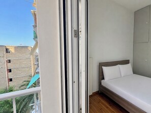 A bedroom with a bed, a wardrobe, and a view of buildings outside. - Athens Metro Escape - Central & Connected by ΜΡS (Athina)