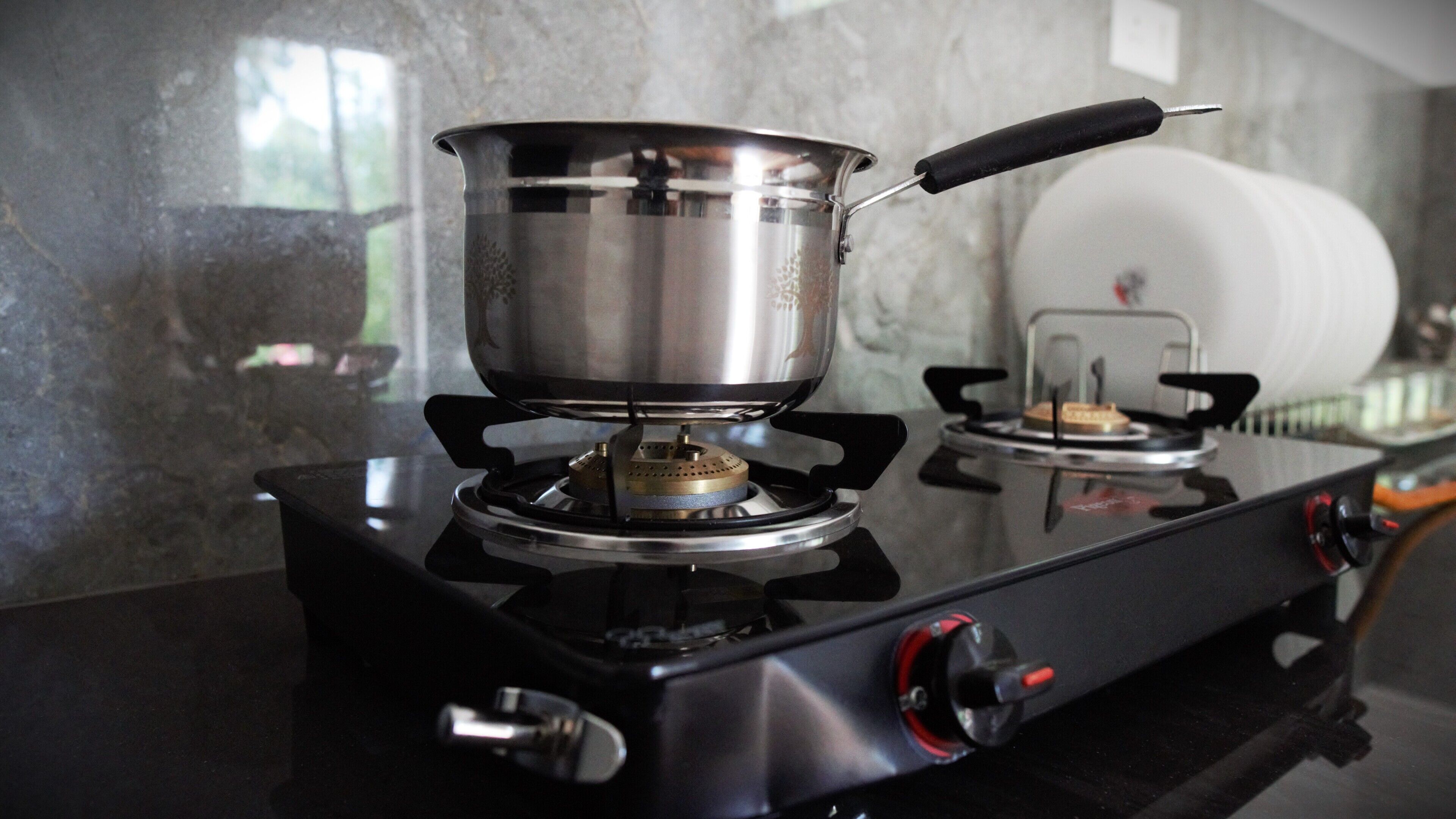 Une cuisinière à gaz avec une casserole dessus, un brûleur à gaz et un bouton de réglage de la cuisinière.