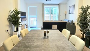 A dining area with a long table, chairs, and a ceiling fan. - Luxury Flat 10 Mins from Station + Bike ! (Cambridge)