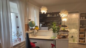 A kitchen with a globe, potted plants, and a variety of kitchenware on shelves. - Studio Jardin Harmonie, sehr elegant wohnen Pantry-Küche, Terrasse, Garten, Pool (Rain)