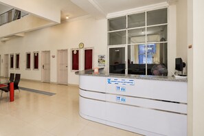 Un área de recepción con mostrador, reloj y ventana.